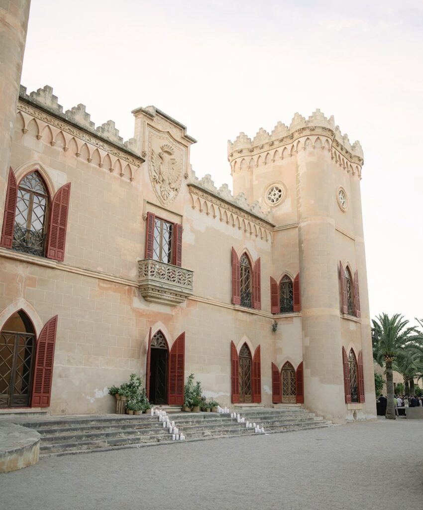 Ein historisches Schloss mit roten Fenstern und Türen, Steintreppen und Topfpflanzen am Eingang – dieser einzigartige Ort ist perfekt für Paare, die auf der Suche nach einer unvergesslichen Hochzeitslocation sind.