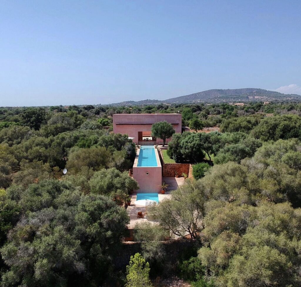 Ein modernes Haus mit einem langen Pool auf Mallorca liegt inmitten von Bäumen – ein idealer Standort für einen Hochzeitsplaner.