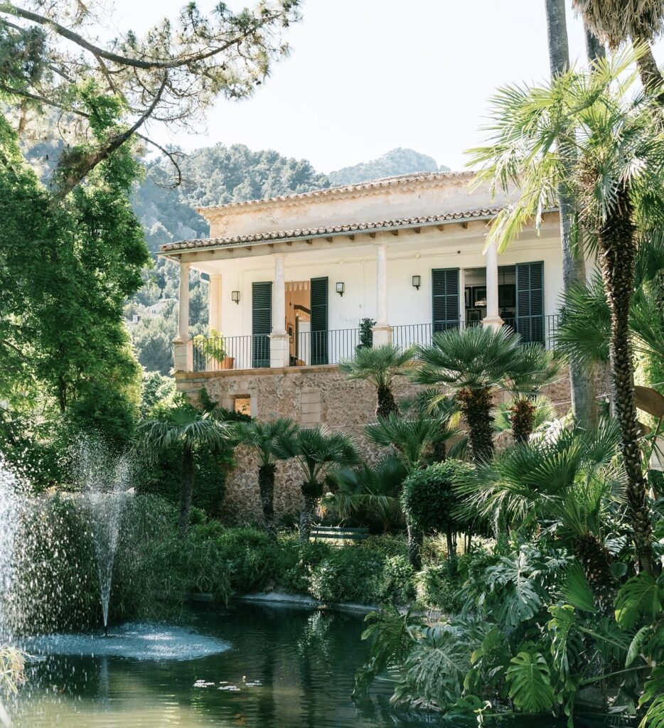 Weiße Villa mit Balkon, üppigem Baumbestand und einem Teich – der ideale Ort für Ihre Hochzeit auf Mallorca.