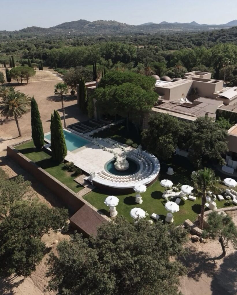 Luftaufnahme einer Villa auf Mallorca – Pool, runde Sitzgruppe, Bäume, weiße Sonnenschirme – die perfekte Hochzeitslocation.