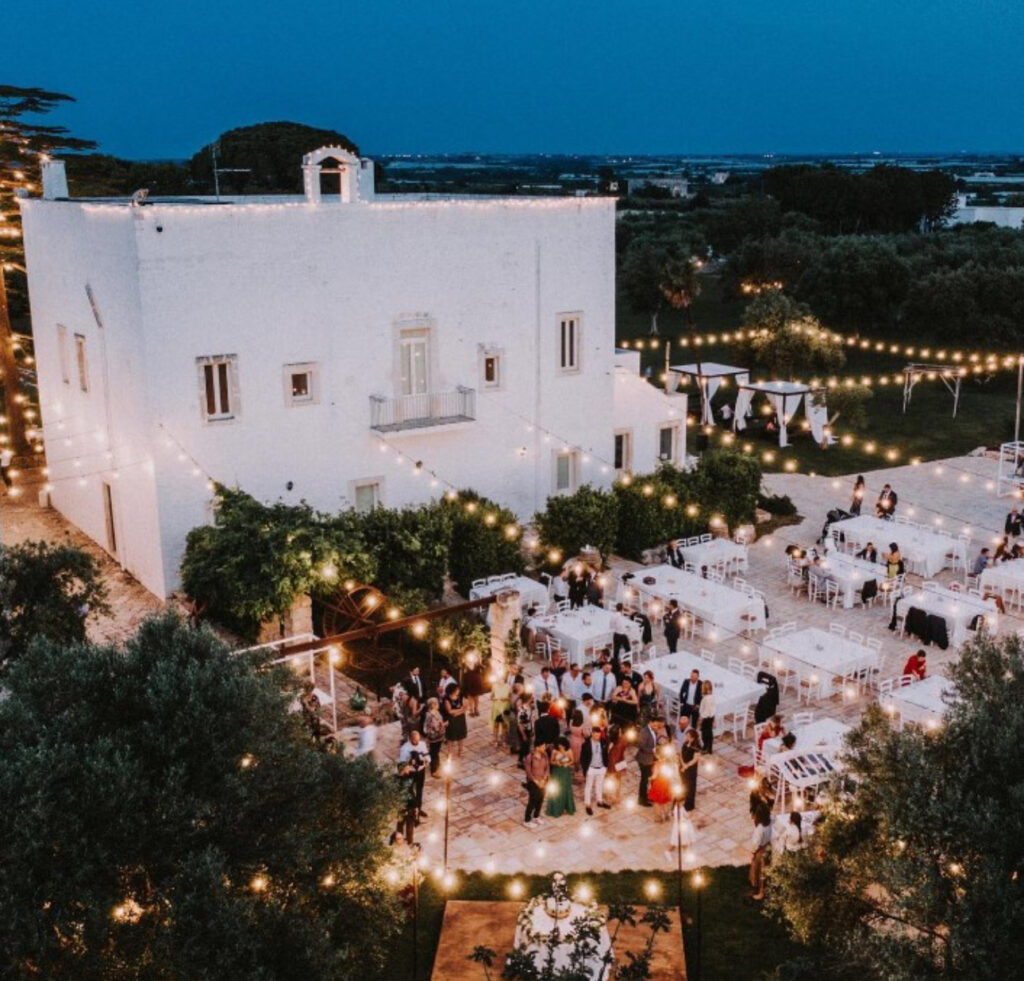 Braut und Bräutigam schreiten lächelnd zum Altar, während die Gäste Fotos von ihrer luxuriösen Hochzeit in Italien machen - eine unvergessliche Hochzeitsfeier.