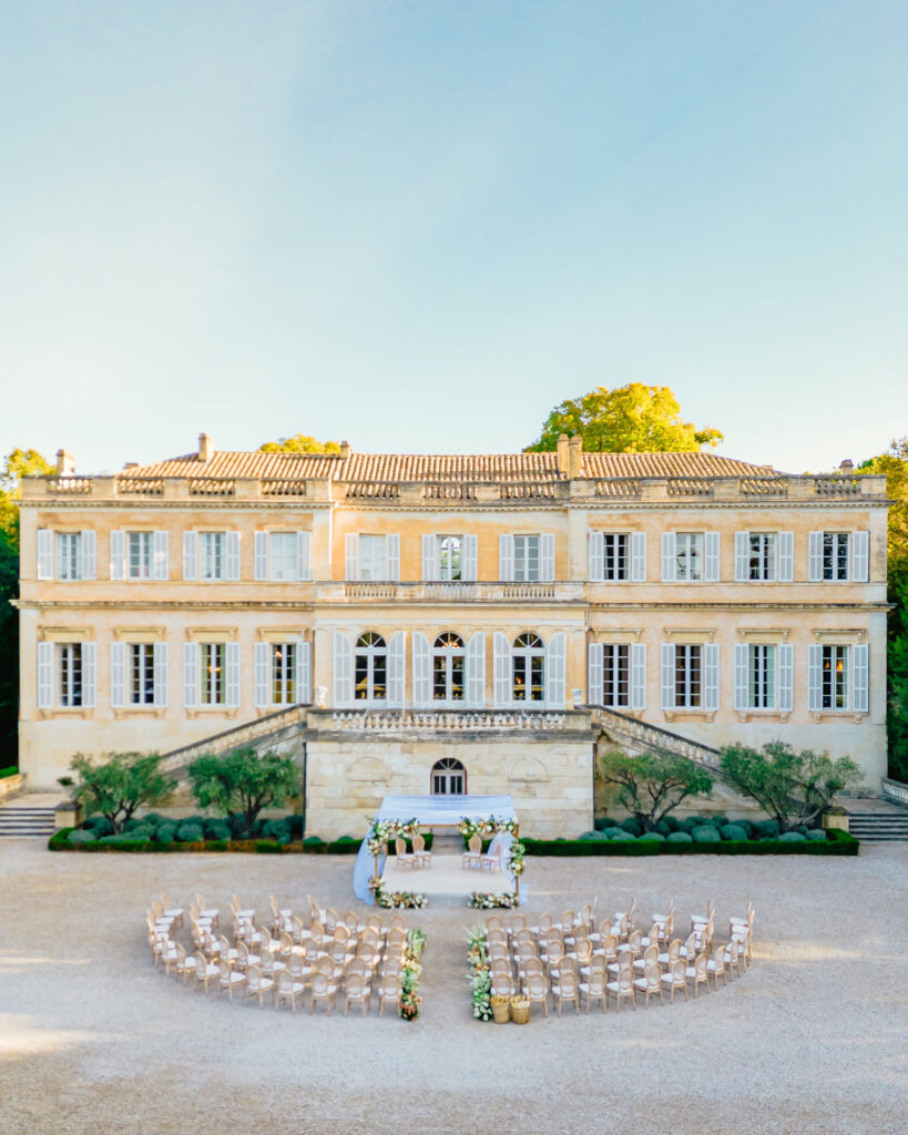 Elegantes Schloss mit einer kreisförmigen Hochzeit im Freien, umgeben von Stühlen und Blumendekorationen - perfekt für eine Hochzeit am Reiseziel, entworfen von einem Top-Hochzeitsplaner in Italien.