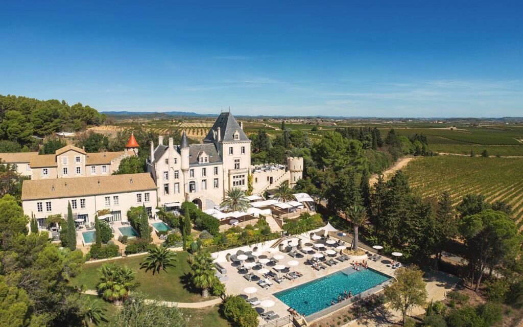 Luftaufnahme eines großen Schlosses mit Pool, Gärten und Weinbergen auf dem Lande unter strahlend blauem Himmel - perfekt für alle, die von einer luxuriösen Hochzeit in Italien träumen, die von einem erfahrenen Hochzeitsplaner in Italien geplant wird.