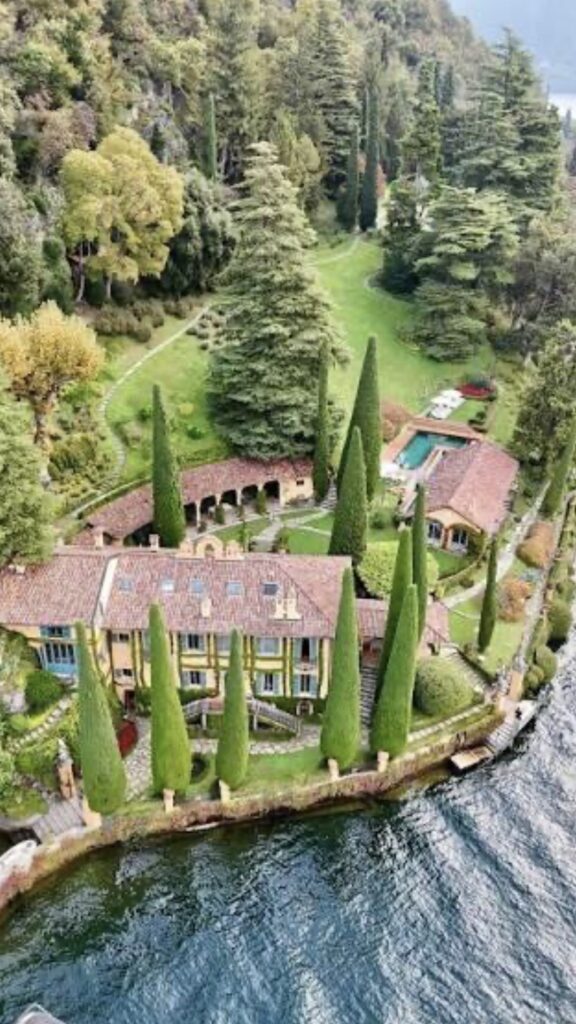 Eine Villa mit roten Dächern, hohen Zypressen und einem Pool am Ufer eines Sees, umgeben von üppigem Grün – dieses bezaubernde Anwesen ist der perfekte Ort für Ihre luxuriöse Hochzeit im Ausland oder eine unvergessliche Hochzeit am Comer See.