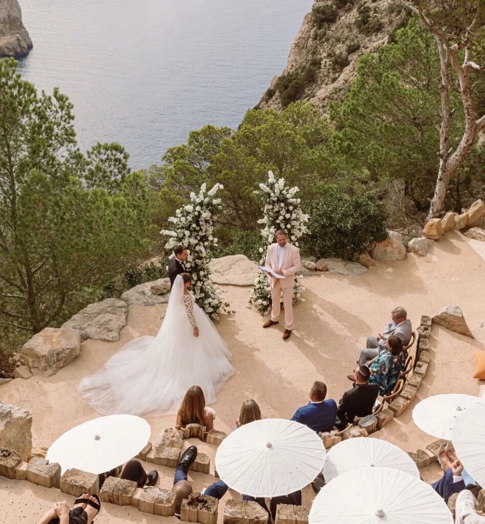 A couple gets married on a cliff in Ibiza during a luxurious wedding ceremony.