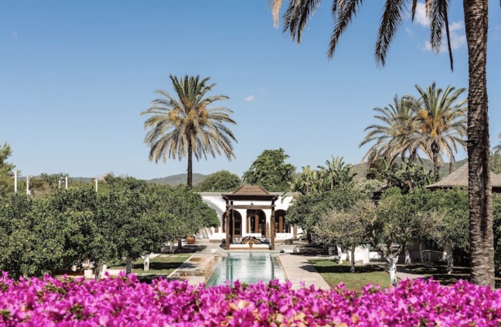A mirrored pond leads to a white building – an ideal location for a luxurious wedding in Ibiza.
