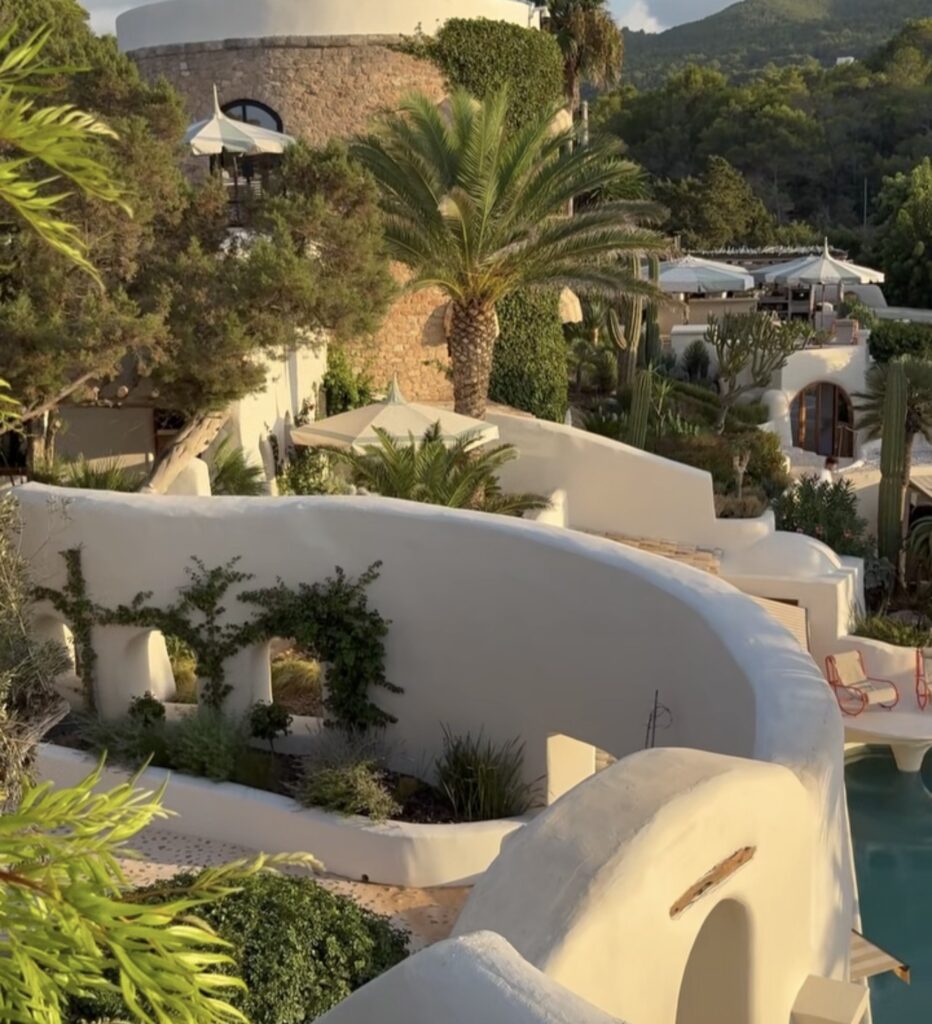 White, curved walls and a terraced garden landscape that surrounds a pool at a luxurious wedding in a special location.